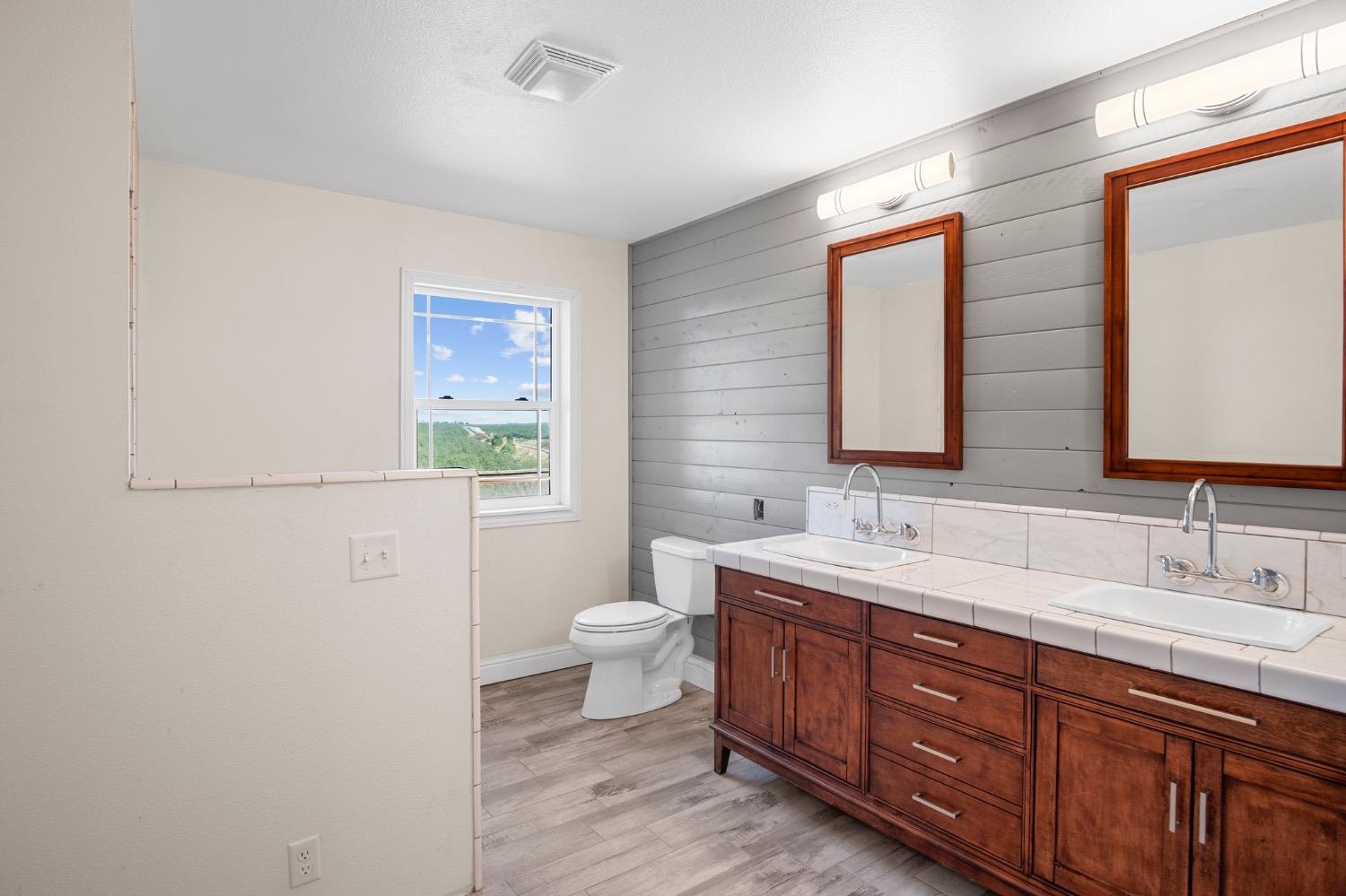 17164 Keyes Road Snelling, CA 95369 - Photo 17 of 51 a bathroom with a double vanity sink a toilet and a mirror