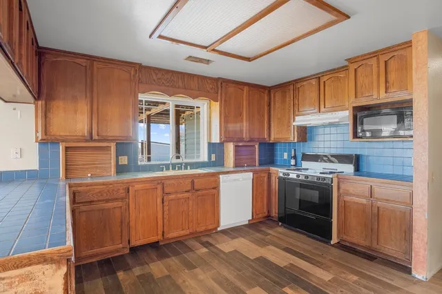 a kitchen with stainless steel appliances granite countertop a stove sink and cabinets