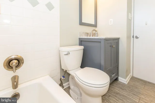 a bathroom with a toilet a sink and mirror