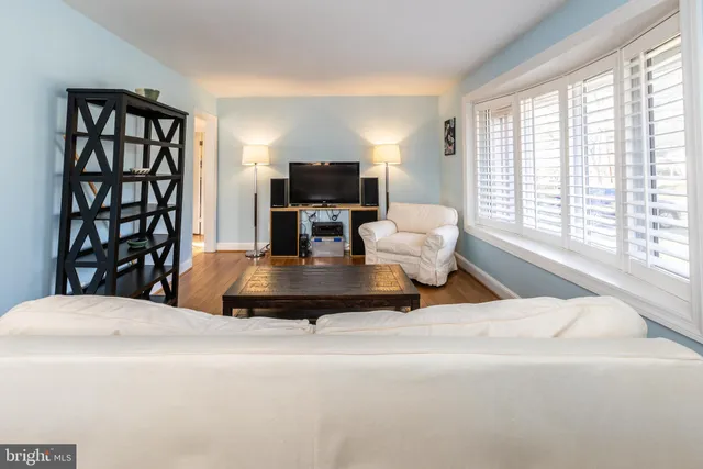 a living room with furniture a flat screen tv and a large window