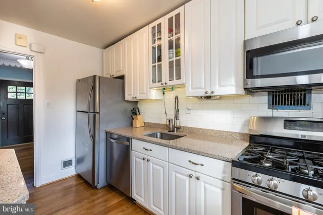 a kitchen with stainless steel appliances granite countertop a refrigerator stove and sink
