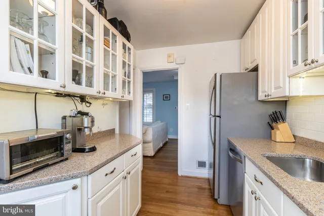 a kitchen with stainless steel appliances granite countertop a sink and a refrigerator