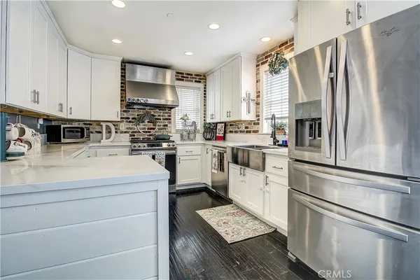 a kitchen with white cabinets and stainless steel appliances