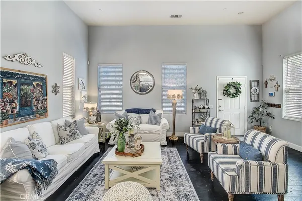 a living room with furniture a clock on wall and a window