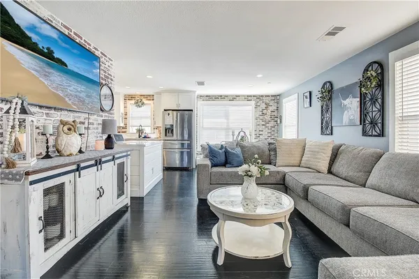 a living room with stainless steel appliances furniture and a kitchen
