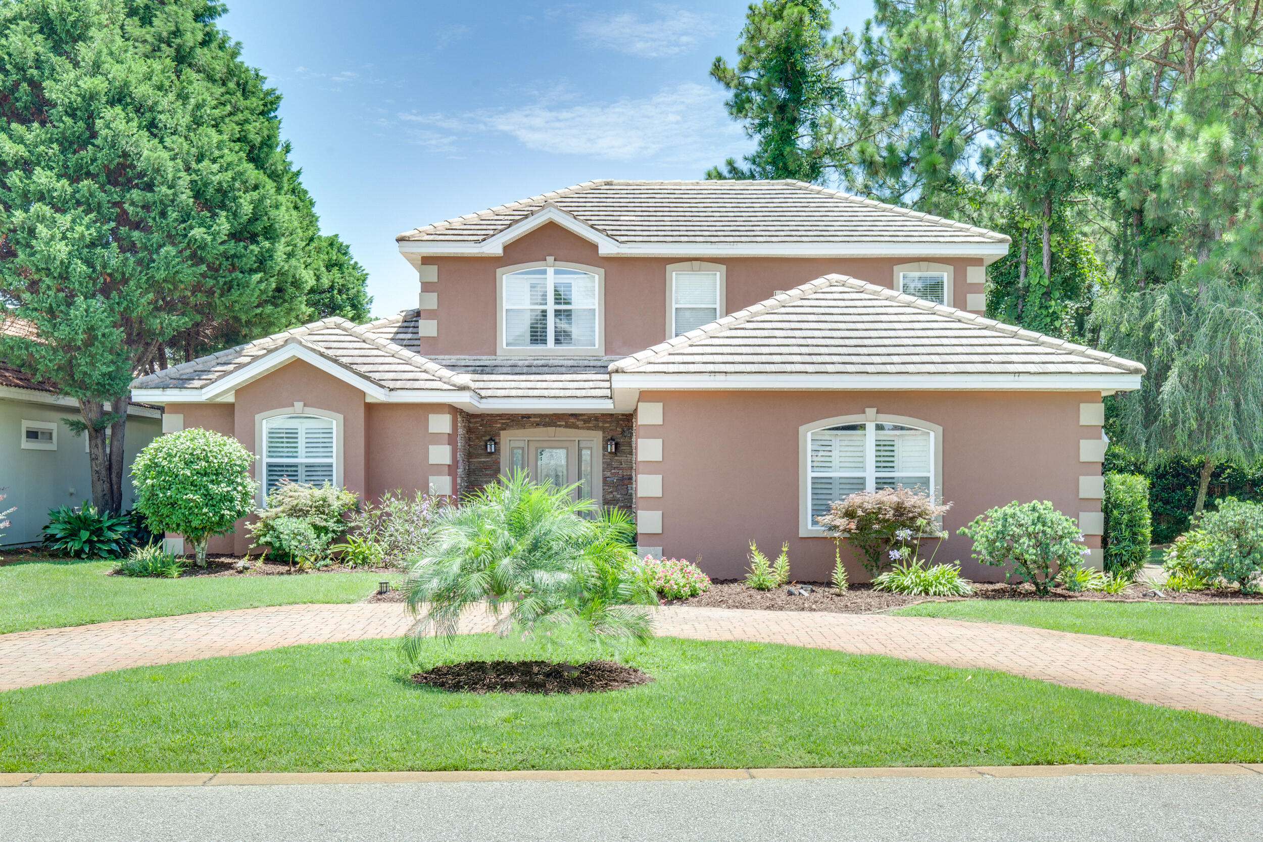 a front view of a house with a yard and potted plants