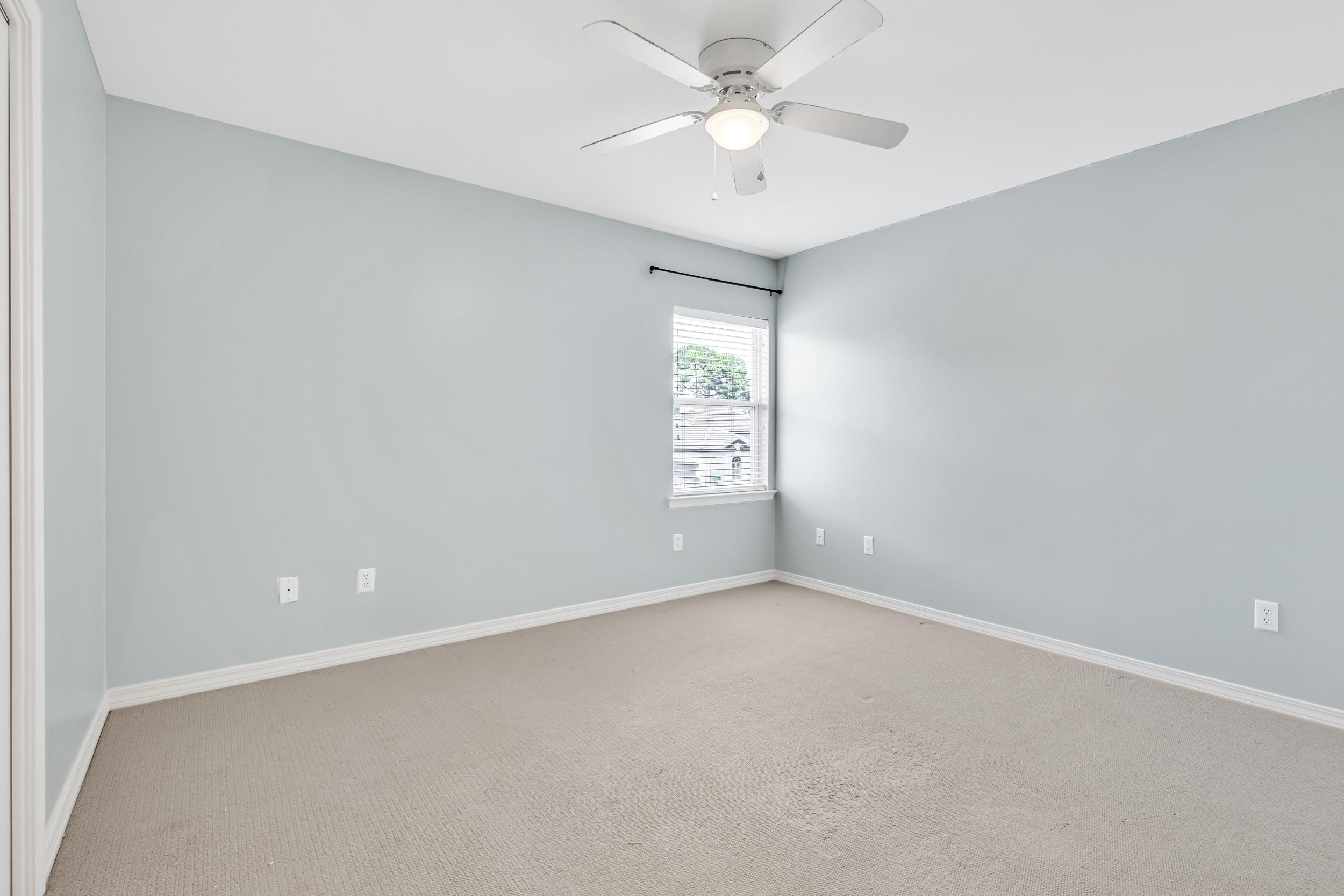 244 Indigo Loop Destin, FL 32550 - Photo 19 of 41 an empty room with a chandelier fan and windows