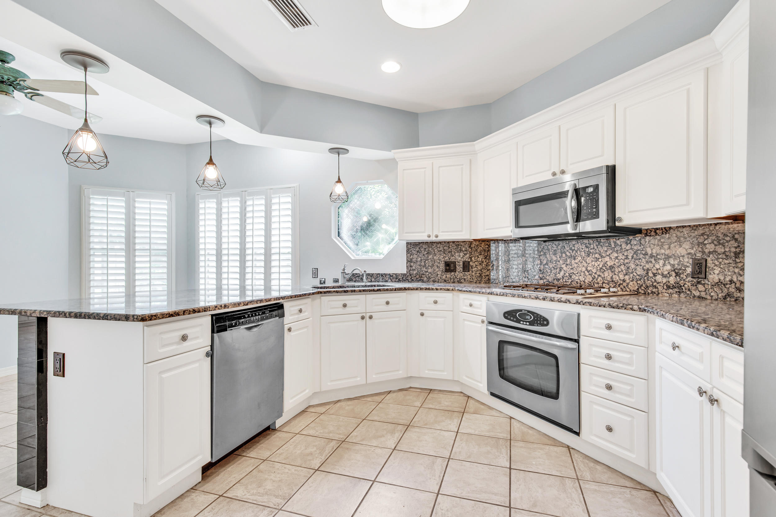 244 Indigo Loop Destin, FL 32550 - Photo 7 of 41 a kitchen with granite countertop white cabinets white appliances sink and dishwasher