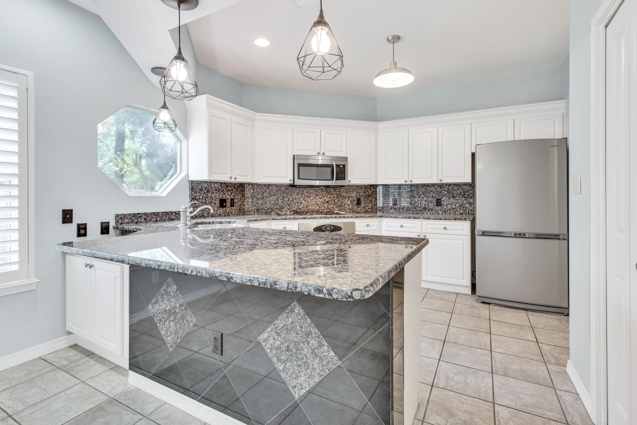 244 Indigo Loop Destin, FL 32550 - Photo 8 of 41 a kitchen with kitchen island granite countertop a sink a counter space appliances and cabinets
