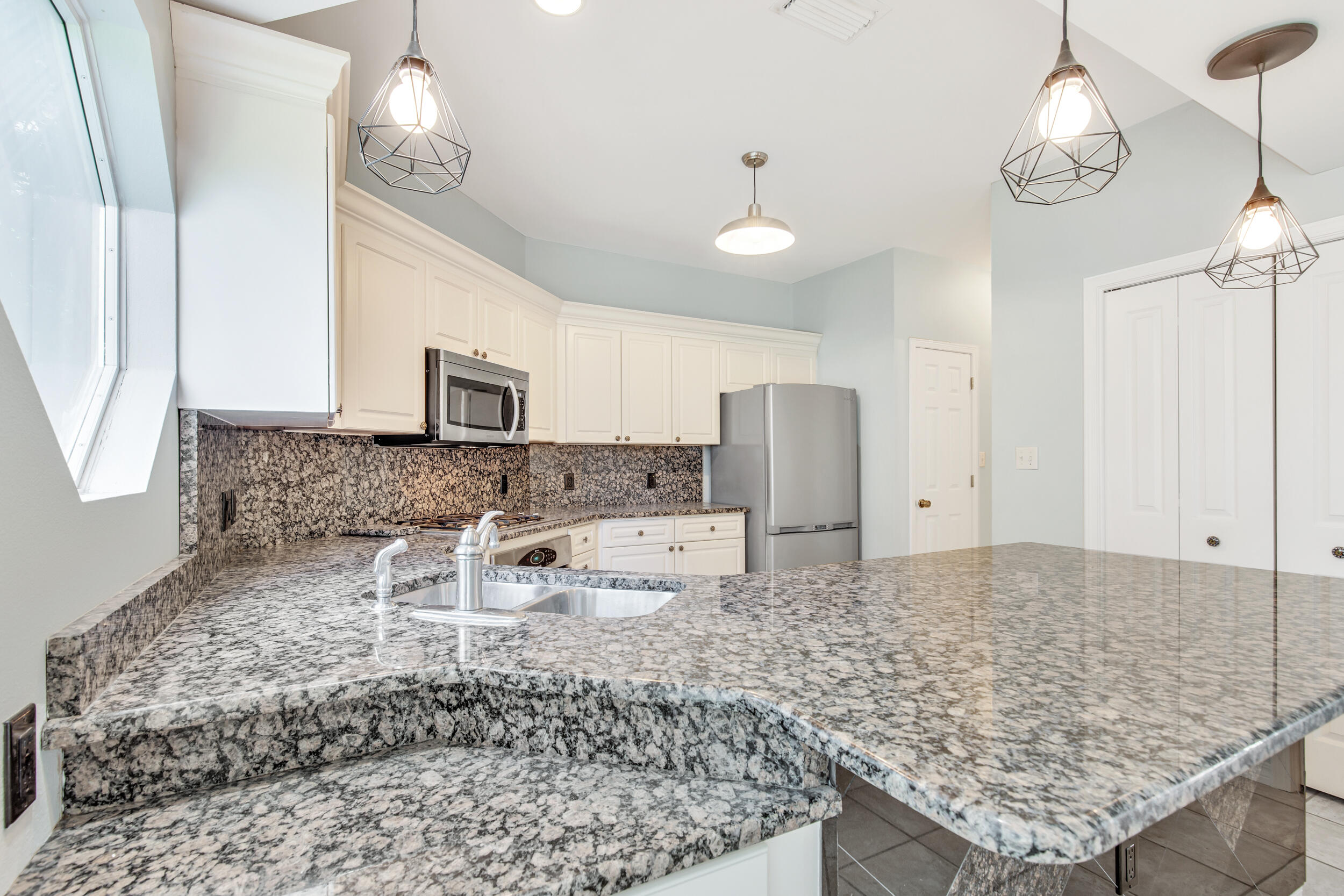 244 Indigo Loop Destin, FL 32550 - Photo 9 of 41 a kitchen with kitchen island granite countertop a sink a counter space and stainless steel appliances