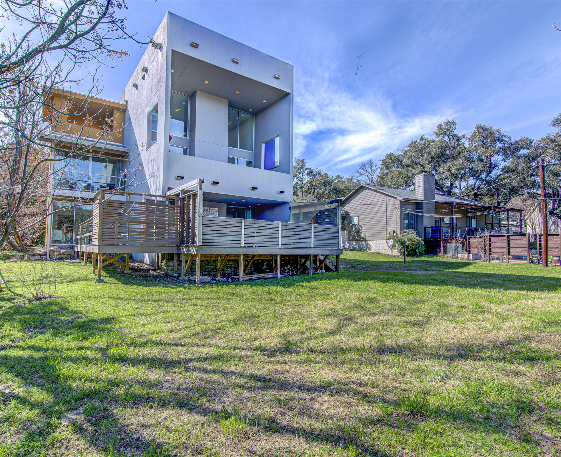 9707 Timber Ridge Pass Austin, TX 78733 - Photo 18 of 18 Bold modern architecture meets open green space with elevated decking and recessed exterior lighting.