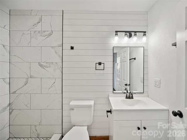a bathroom with a sink toilet and mirror