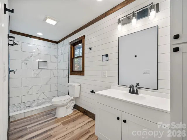 a bathroom with a sink toilet a mirror and shower