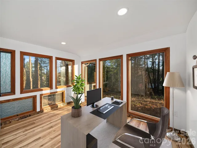 a living room with hardwood floor and large windows