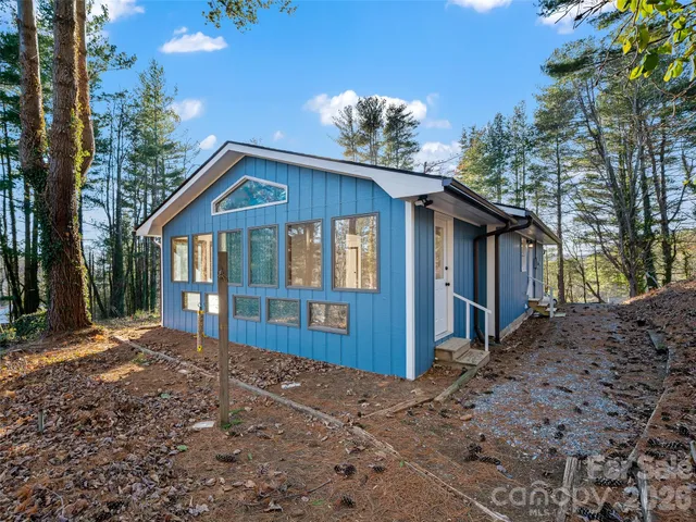 a front view of a house with a yard and trees