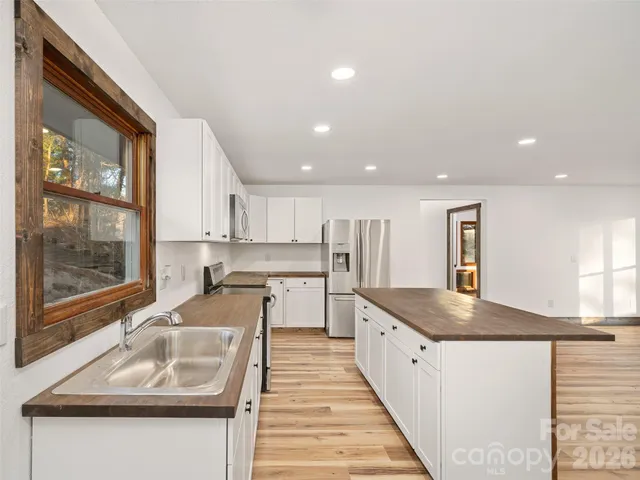 a kitchen with stainless steel appliances granite countertop a sink and a stove
