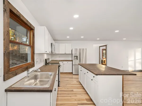 a kitchen with stainless steel appliances granite countertop a sink and a stove