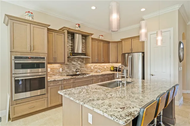 a kitchen with kitchen island granite countertop a sink and refrigerator