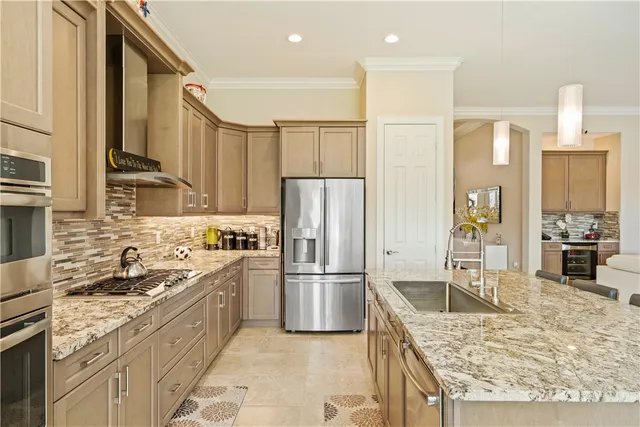 a kitchen with stainless steel appliances granite countertop a sink stove and refrigerator
