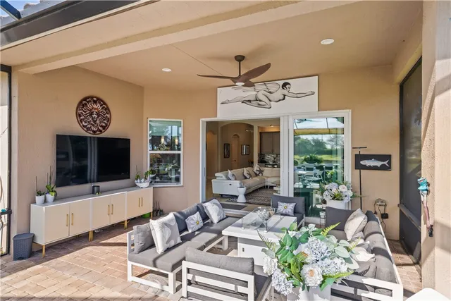 a living room with furniture a flat screen tv and a large window