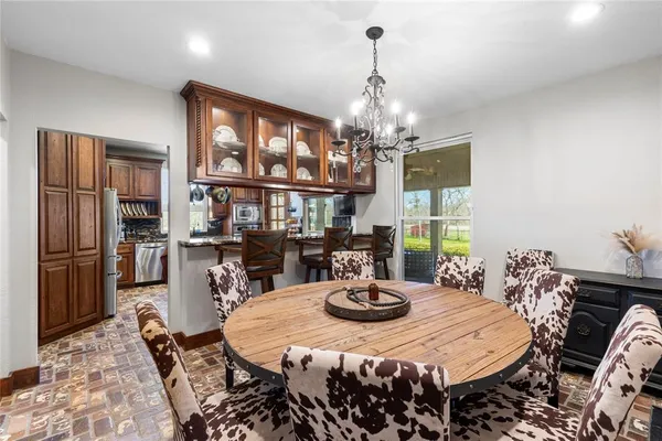 a view of a dining room with furniture a chandelier and wooden floor