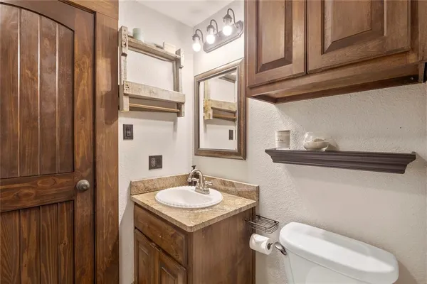 a bathroom with a sink a toilet and shower curtain