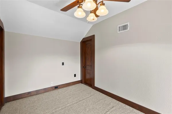 an empty room with a chandelier fan