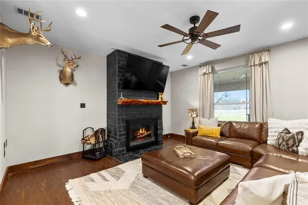 a living room with furniture a fireplace and a flat screen tv