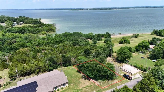 an aerial view of a house with a yard and lake view