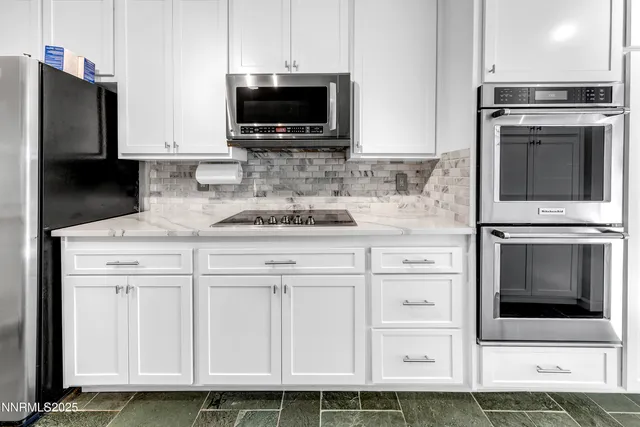 a kitchen with white cabinets and stainless steel appliances