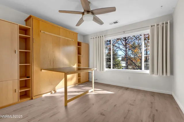 a bed sitting in a spacious bedroom next to a window