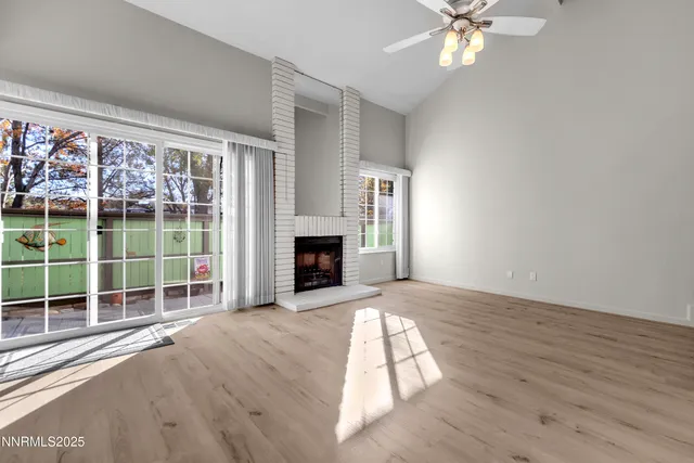 wooden floor fireplace and windows in an empty room