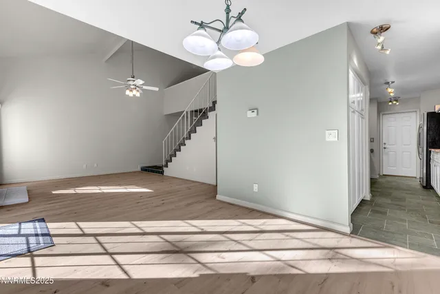 a view of a livingroom with wooden floor and a ceiling fan