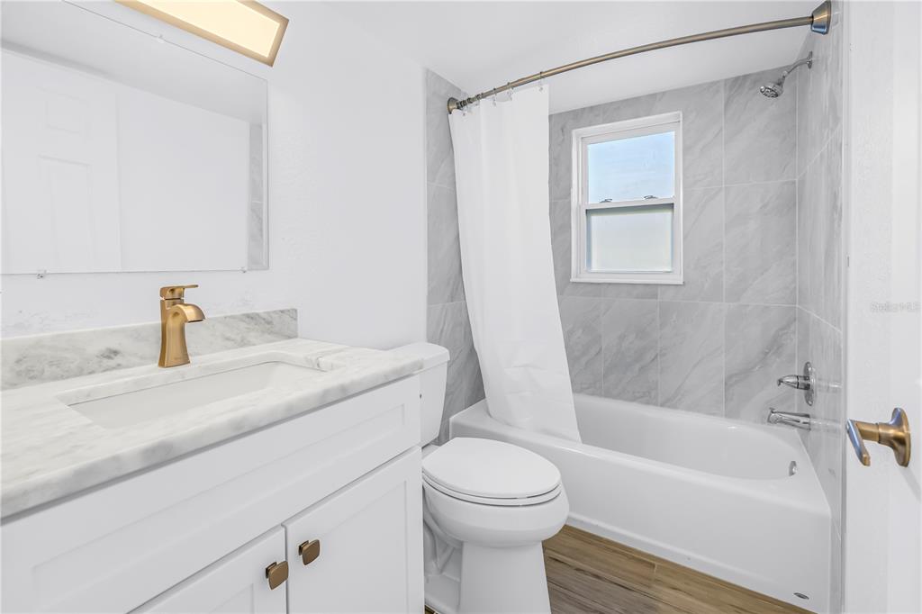 8630 Blind Pass Road St. Pete Beach, FL 33706 - Photo 23 of 26 a bathroom with a granite countertop sink toilet and shower