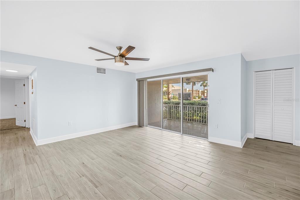 8630 Blind Pass Road St. Pete Beach, FL 33706 - Photo 10 of 26 an empty room with wooden floor fan and windows