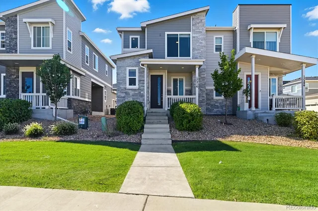 a front view of a house with garden and trees