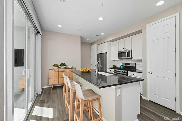 a kitchen that has a lot of cabinets a sink and appliances in it