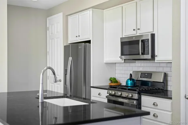 a kitchen with stainless steel appliances granite countertop a stove a sink and a refrigerator