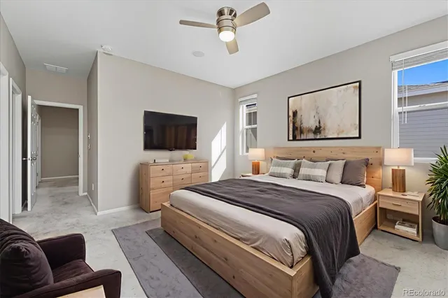 a spacious bedroom with a bed a television and a couch