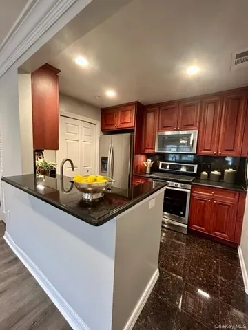 a kitchen with granite countertop a stove sink and cabinets