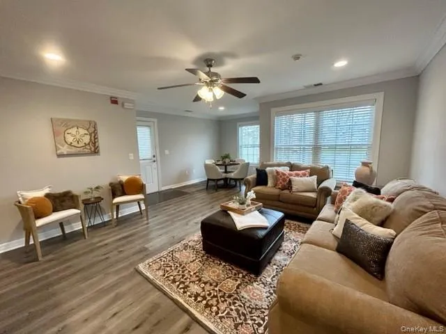 a living room with furniture ceiling fan and a window