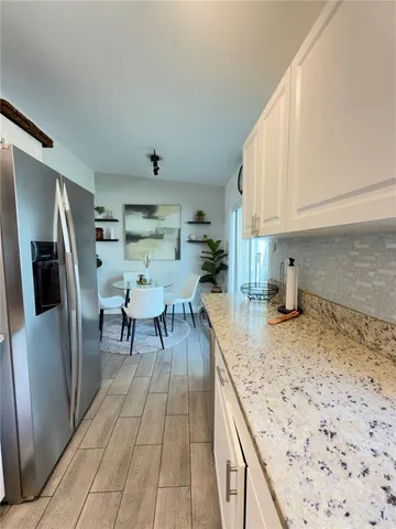 a kitchen with stainless steel appliances granite countertop a sink refrigerator and cabinets