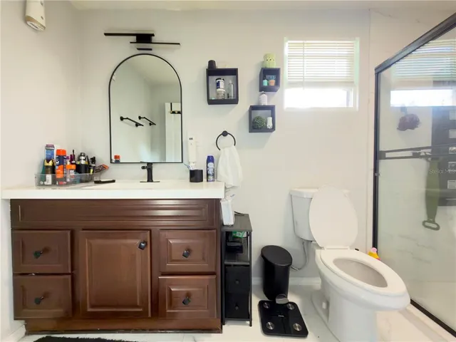 a bathroom with a granite countertop toilet sink and mirror