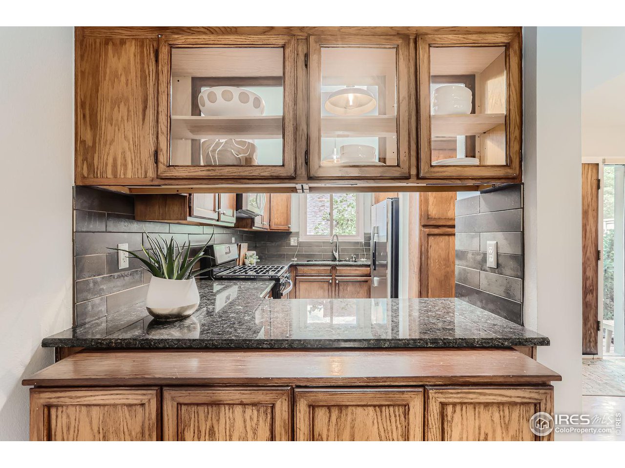 3075 Edison Court Boulder, CO 80301 - Photo 10 of 28 a kitchen with granite countertop a refrigerator a sink and cabinets