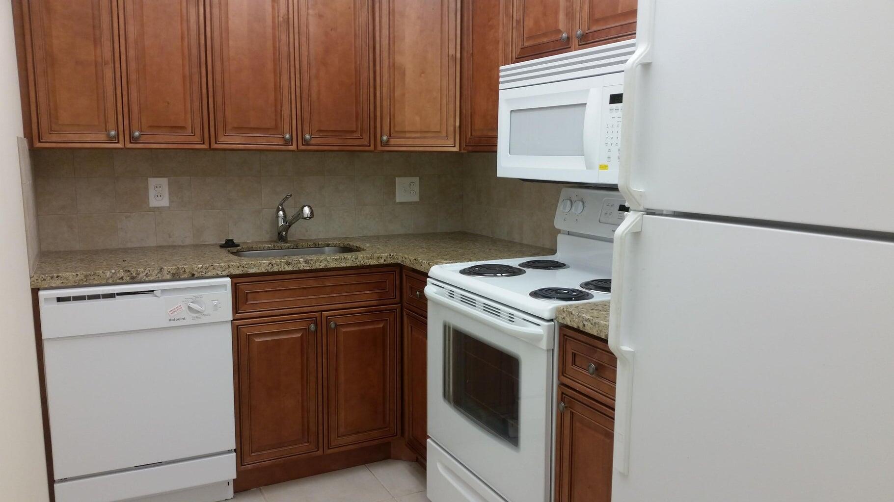 642 Northwest 13th Street, Unit 24 Boca Raton, FL 33486 - Photo 5 of 9 a kitchen with granite countertop cabinets stainless steel appliances and a sink