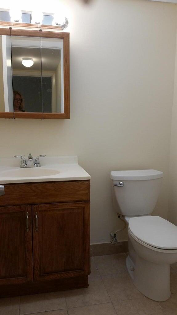 642 Northwest 13th Street, Unit 24 Boca Raton, FL 33486 - Photo 8 of 9 a bathroom with a toilet sink and mirror