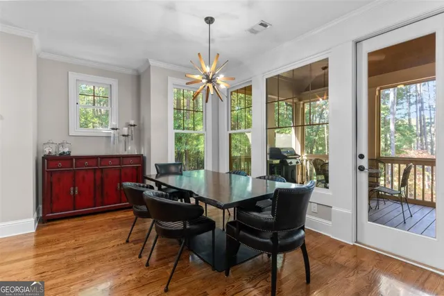 a kitchen with stainless steel appliances granite countertop a refrigerator a stove top oven a sink dishwasher and a dining table with wooden floor