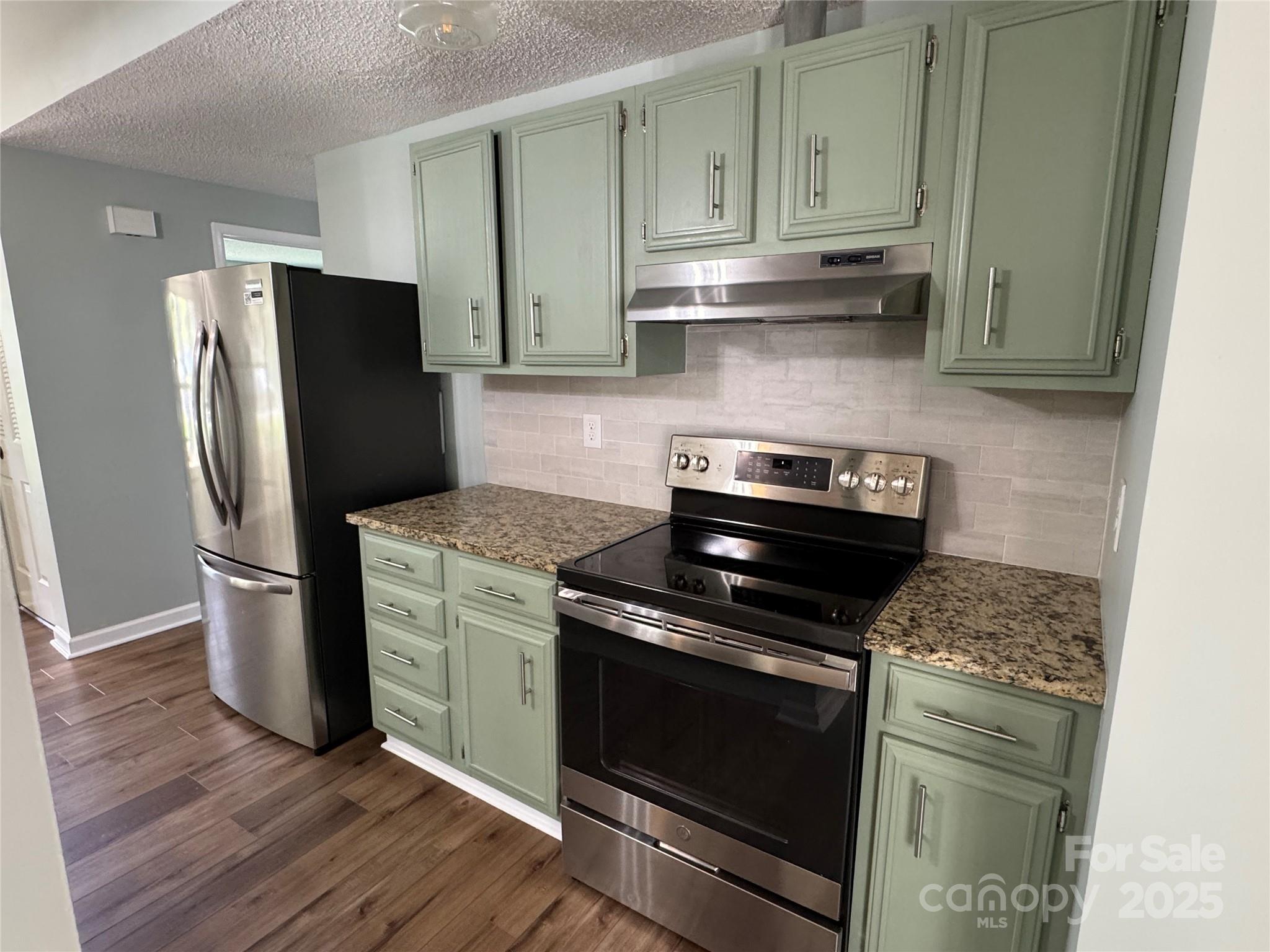7939 Holly Hill Road Charlotte, NC 28227 - Photo 12 of 38 a kitchen with stainless steel appliances granite countertop a stove a refrigerator and a cabinets