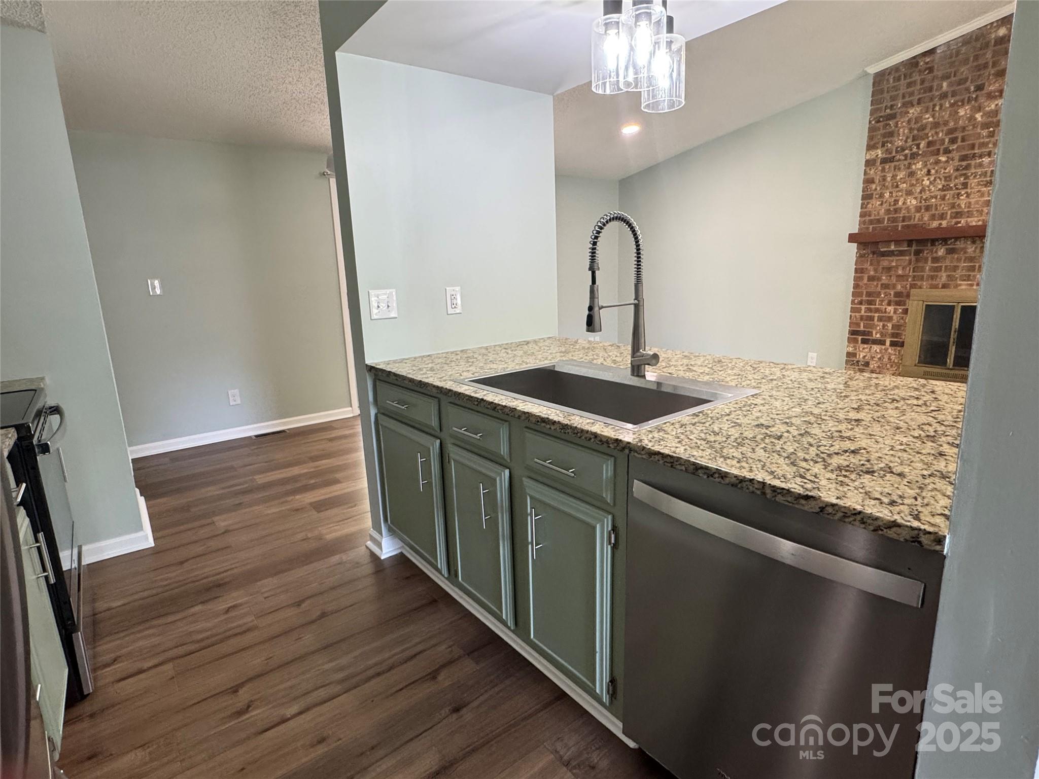 7939 Holly Hill Road Charlotte, NC 28227 - Photo 13 of 38 a kitchen with stainless steel appliances granite countertop a sink dishwasher and a stove with wooden floor