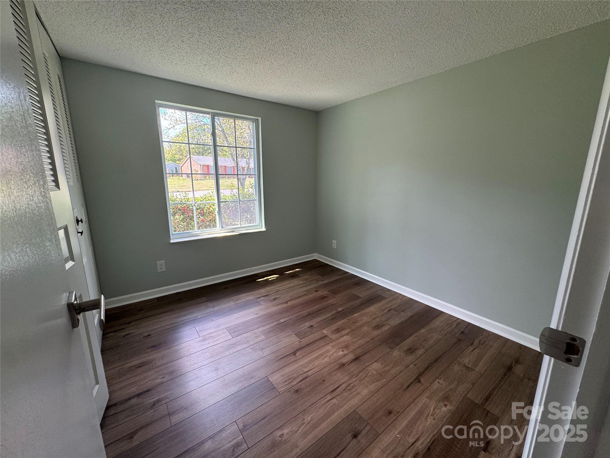 7939 Holly Hill Road Charlotte, NC 28227 - Photo 19 of 38 an empty room with wooden floor and windows